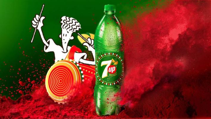 Mascot Fido Dido plays a traditional dhak drum. He stands next to a bottle of 7Up, which has been designed with festive Indian motifs. The image if clouded in a puff of red powder.